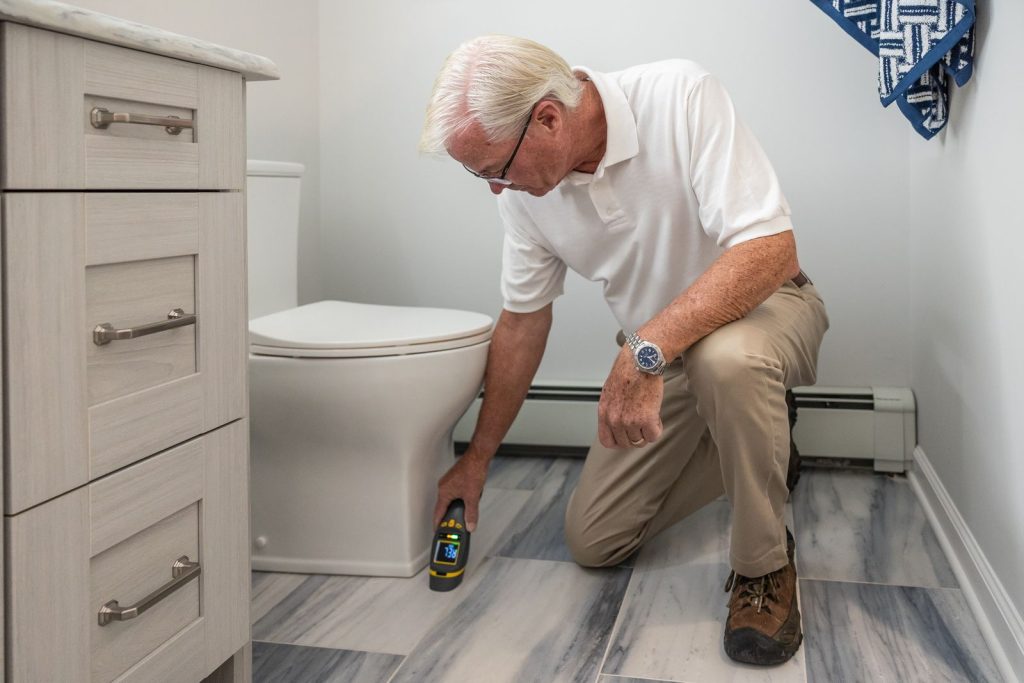 Technician checking a bathroom floor drain line with an inspection device