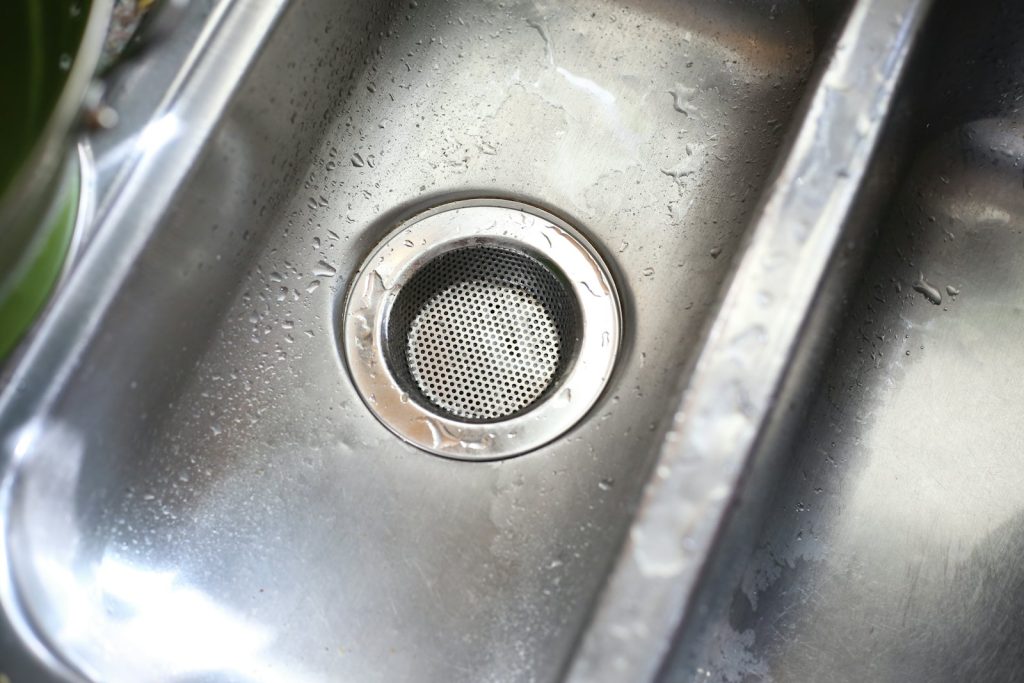 Stainless steel sink with a strainer basket