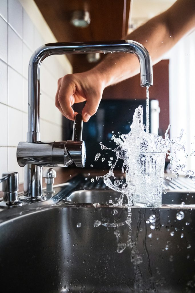 Hand turning on a kitchen tap
