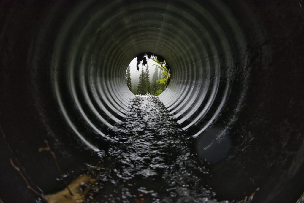 Inside a large concrete drainage pipe